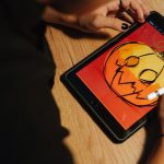 Creating a Halloween pumpkin illustration on a tablet with a stylus.
